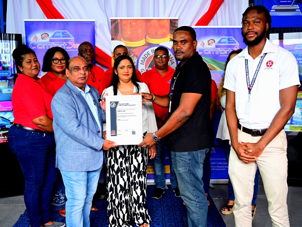 CEO and Director of Comfort Sleep Mr. Dennis Charran receive the Permit to use the Made in Guyana Standards Mark from Technical Officer of the GNBS Mr. Keon Rankin